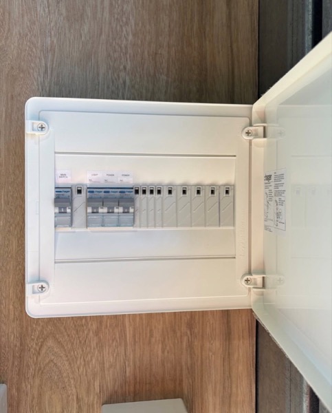 An open switchboard with rows of circuit breakers and wiring