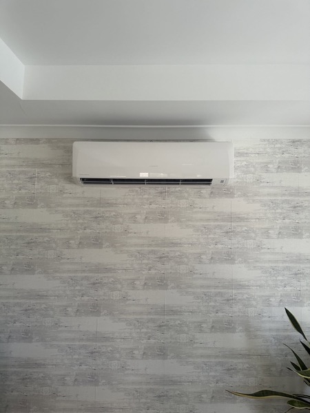 A wall mounted split system air conditioner above timber look wall tiles