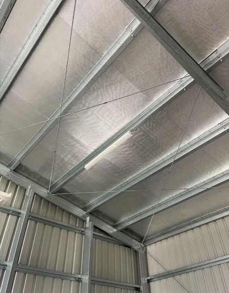 Light fittings mounted along the roof frame inside a shed