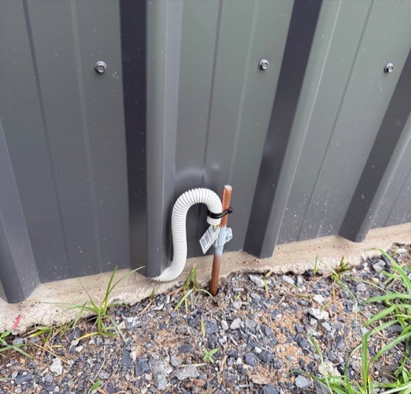 Conduit running down to the base of a shed wall