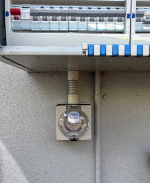 An electricity meter mounted on an outside wall