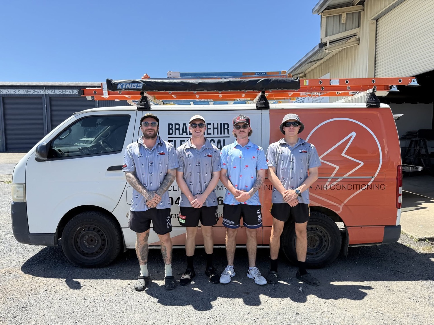 Four electricians standing beside the branded Brad Hehir Electrical van