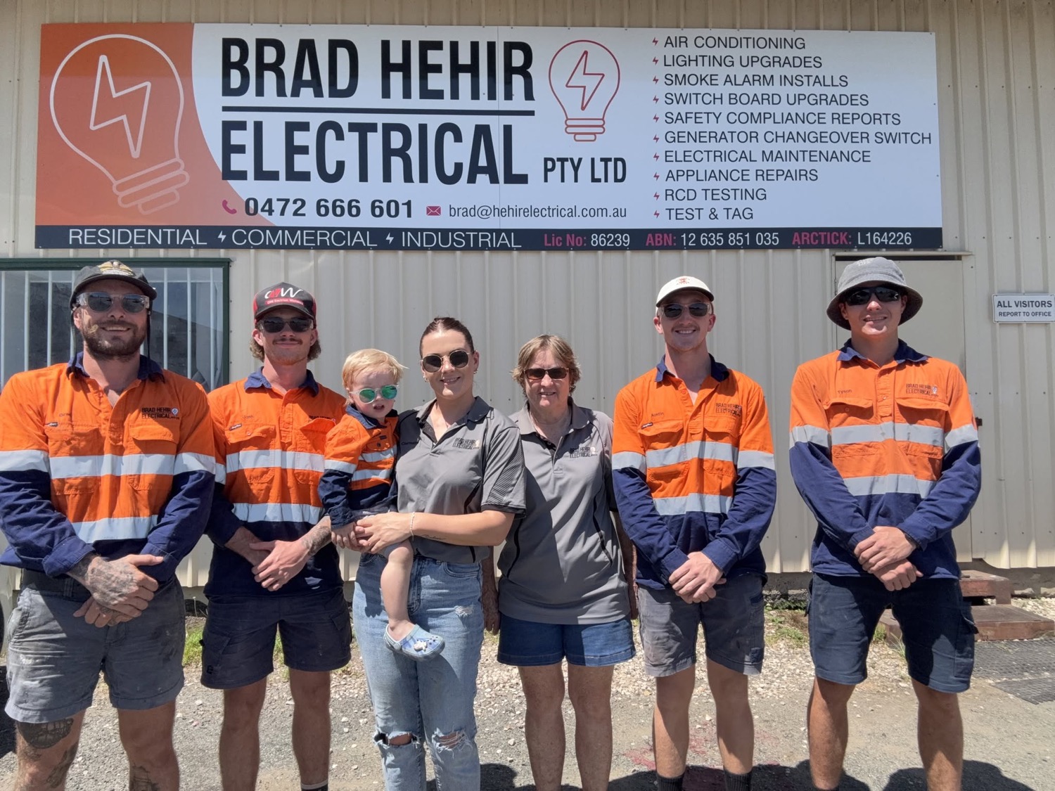 The team standing in front of the Brad Hehir Electrical signage at their premises