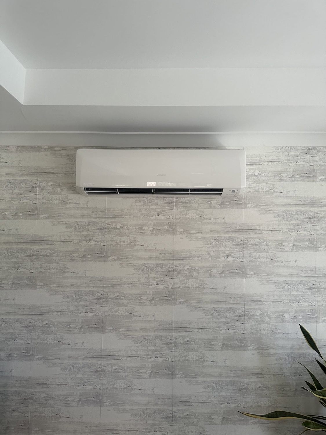 A wall mounted split system air conditioner above timber look wall tiles